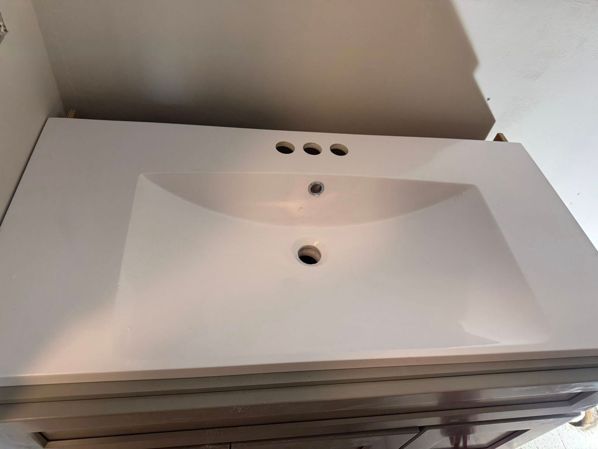 White bathroom sink with three faucet holes.