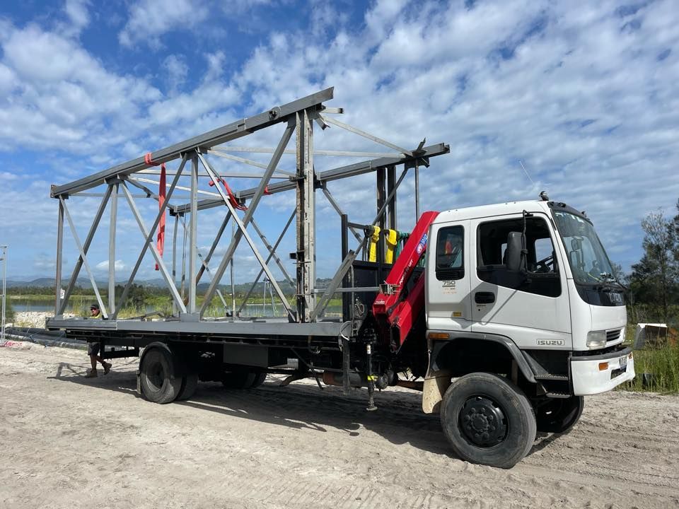 A White Truck With A Crane On The Back Is Parked In A Dirt Field — East Coast Metal Recycling In Tugun, QLD