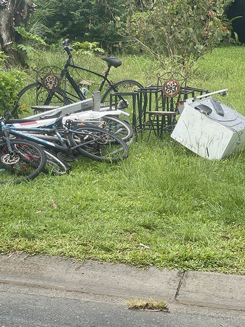 A Bunch Of Bicycles Are Sitting In The Grass Next To A Table And Chairs — East Coast Metal Recycling In Tugun, QLD