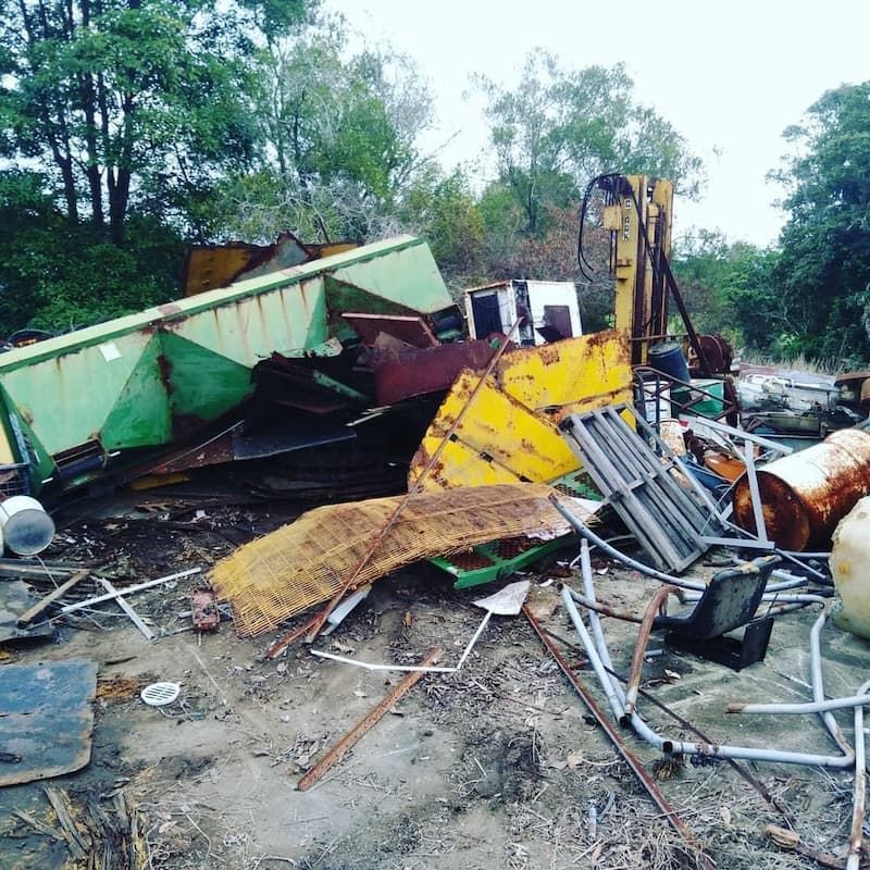 A Pile Of Scrap Metal Is Sitting On The Ground In A Field — East Coast Metal Recycling In Brisbane, QLD