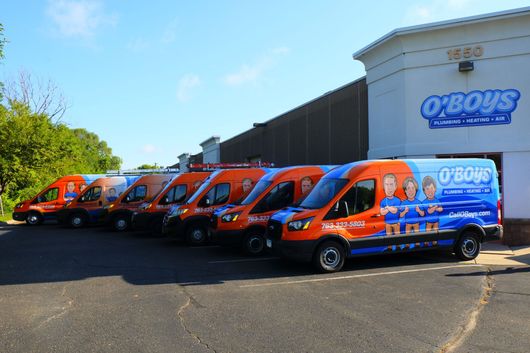 A row of o ' boys vans are parked in front of a building
