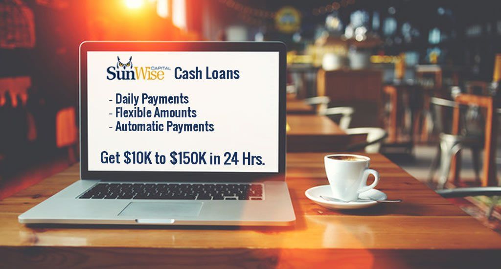 A laptop computer is sitting on a wooden table next to a cup of coffee.