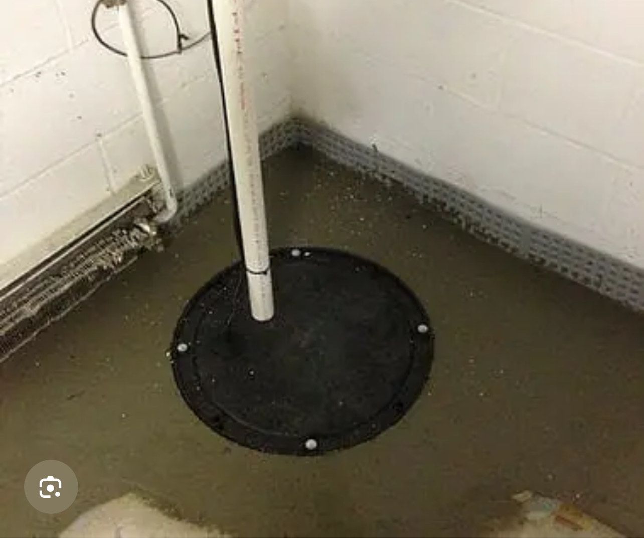 HVAC technician in blue uniform inspecting an air conditioning unit outside a brick building.