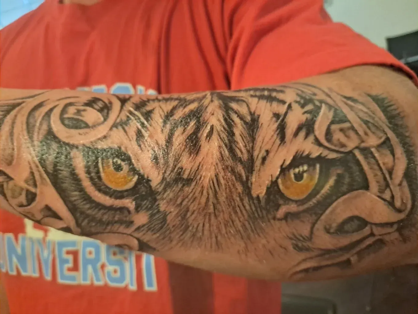A man has a tattoo of a tiger on his arm