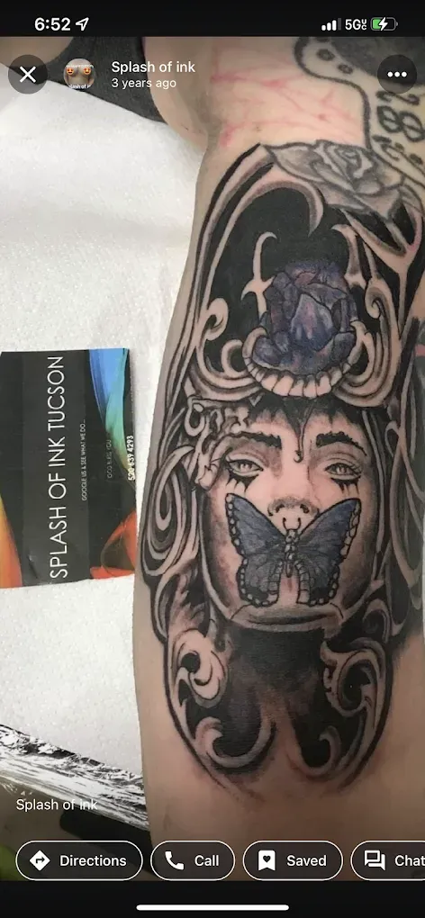 A person has a tattoo of a woman with a butterfly on her face.