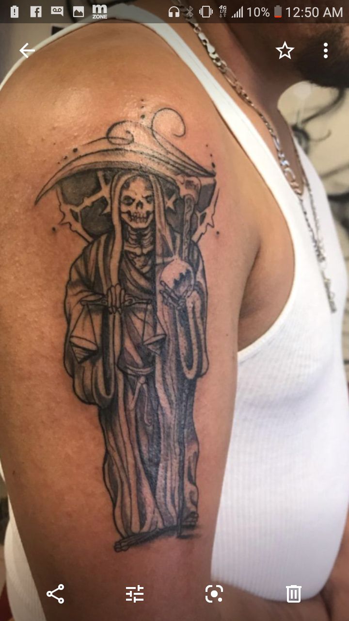 A man has a grim reaper tattoo on his arm