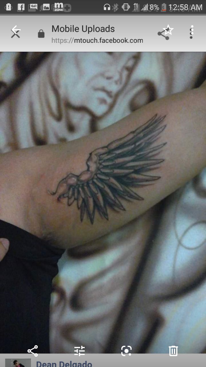 A person has a tattoo of a wing on their arm