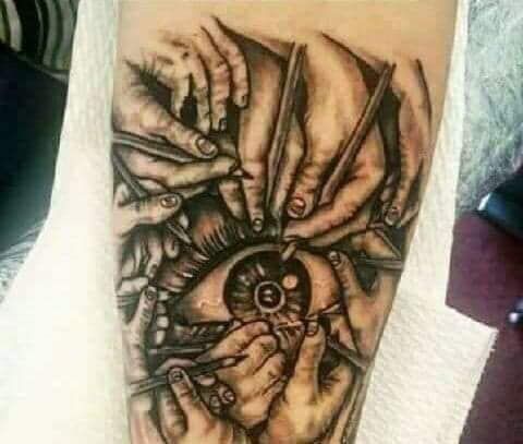 A tattoo of a person 's eye being operated on with scissors.