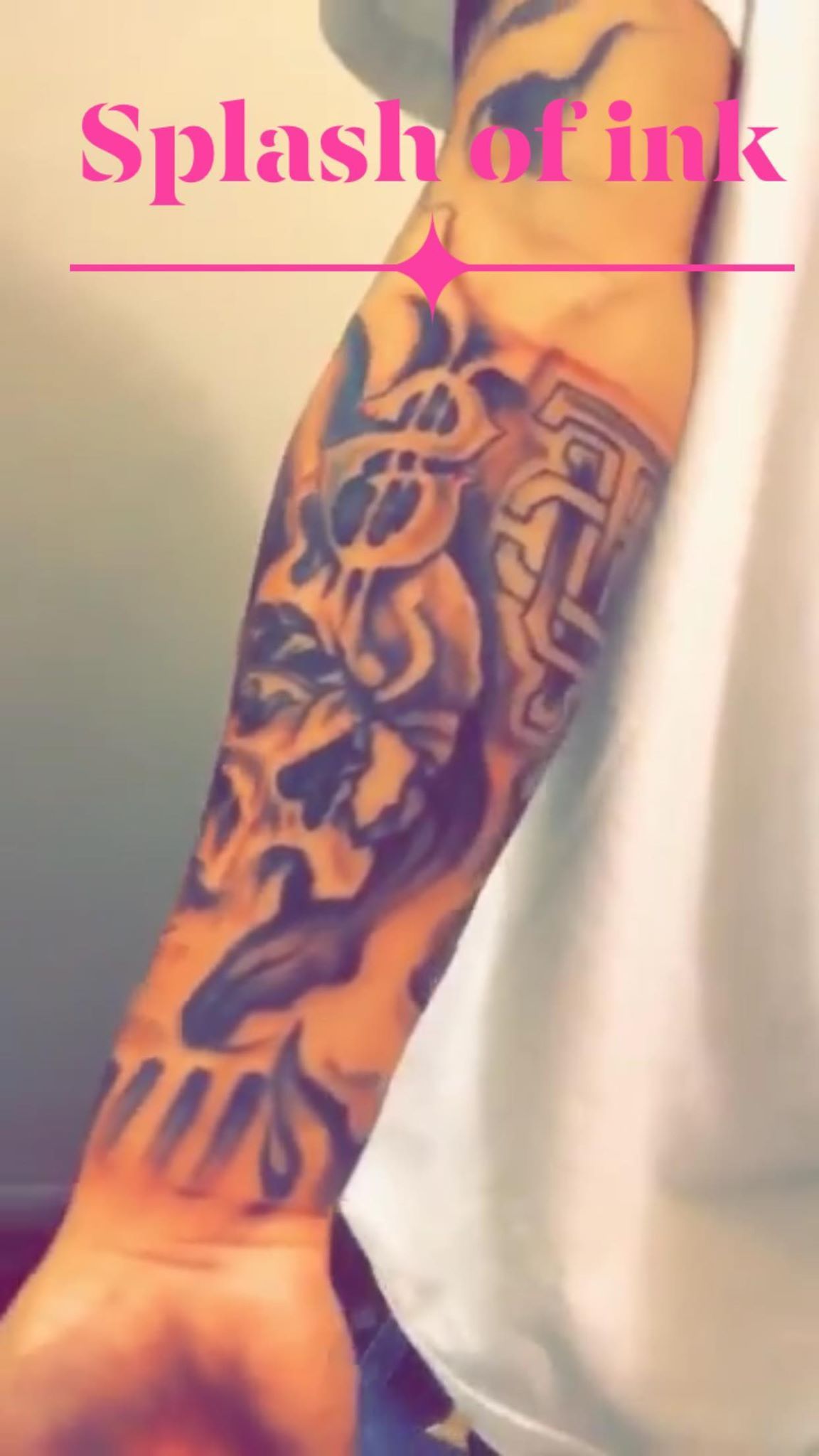 A man has a tattoo on his arm that says splash of ink