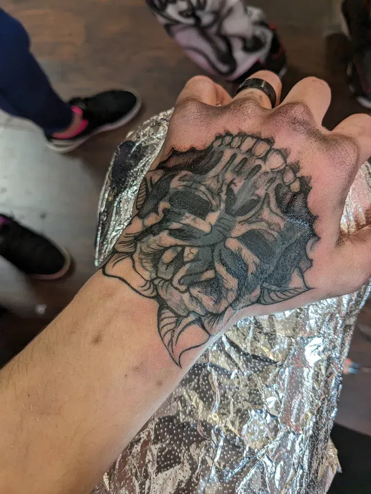 A close up of a person 's hand with a tattoo on it.