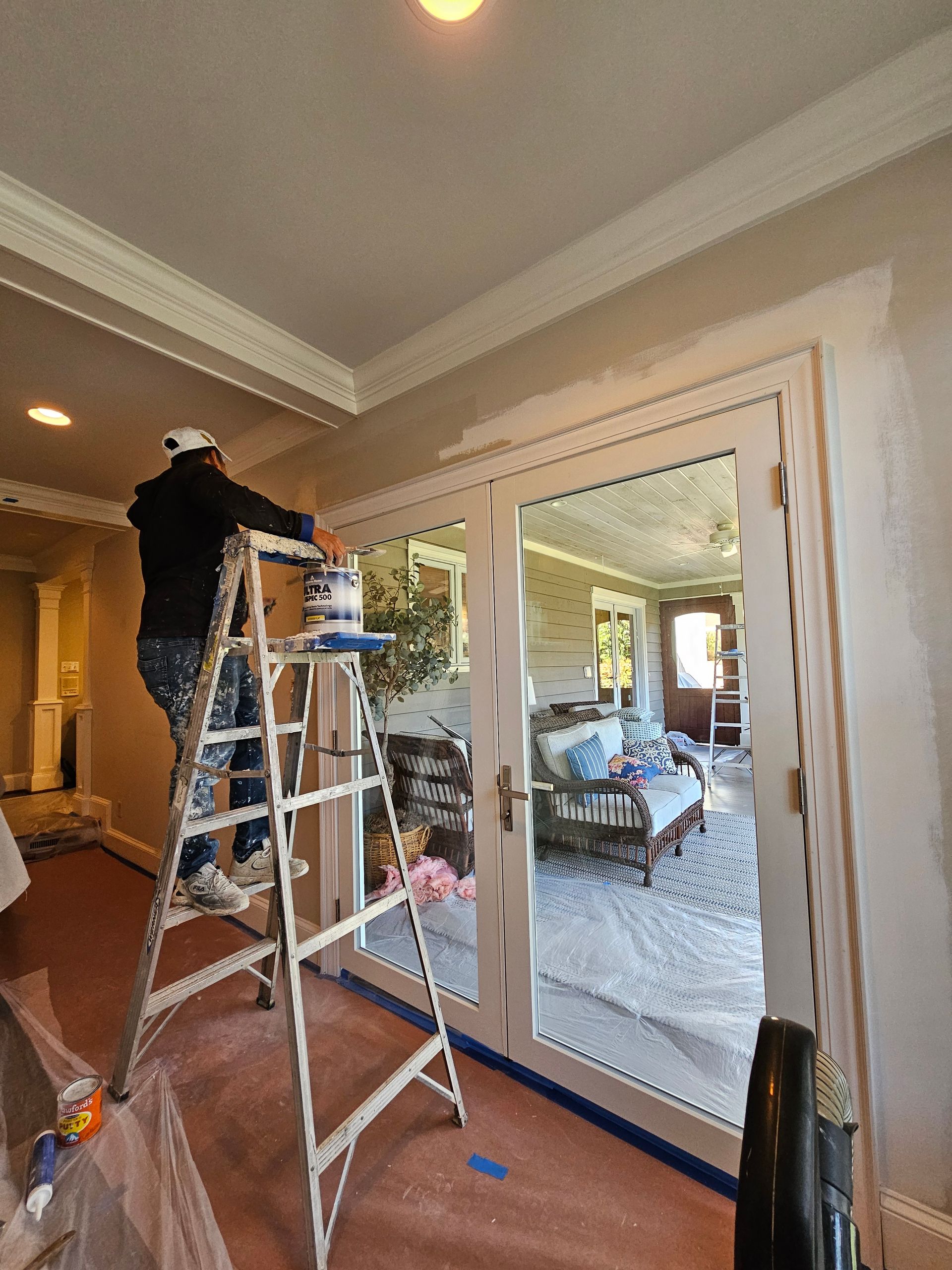 Man using a pressure washer to cleani the brick walkway of a house, removing dirt and grime efficiently.