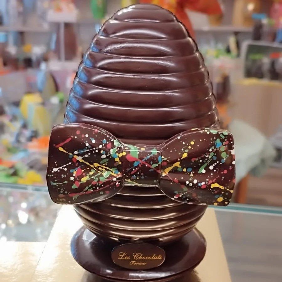 Scultura di cioccolato a forma di alveare con un papillon colorato; esposta all'interno.