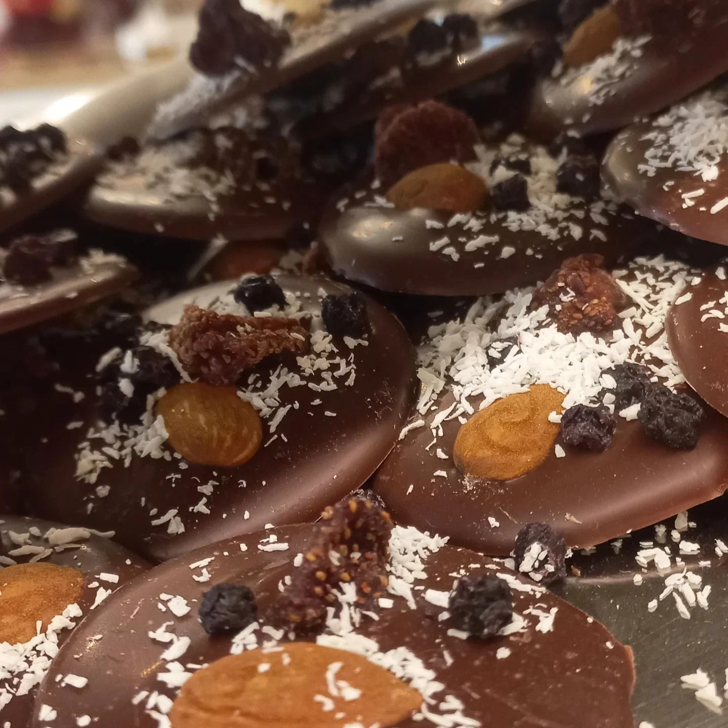 Dischi di cioccolato con frutta secca, mandorle e scaglie di cocco.