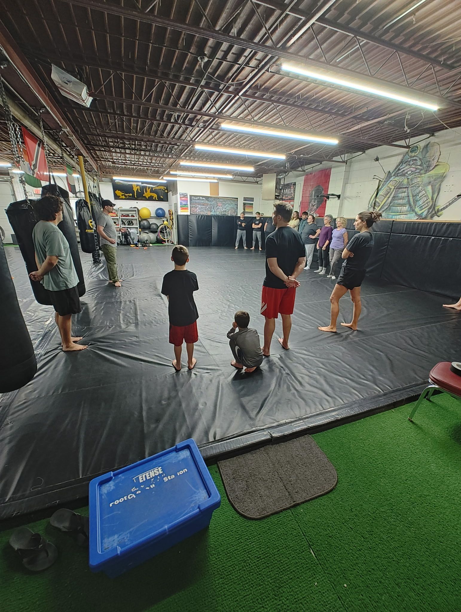 A group of people are standing in a gym.