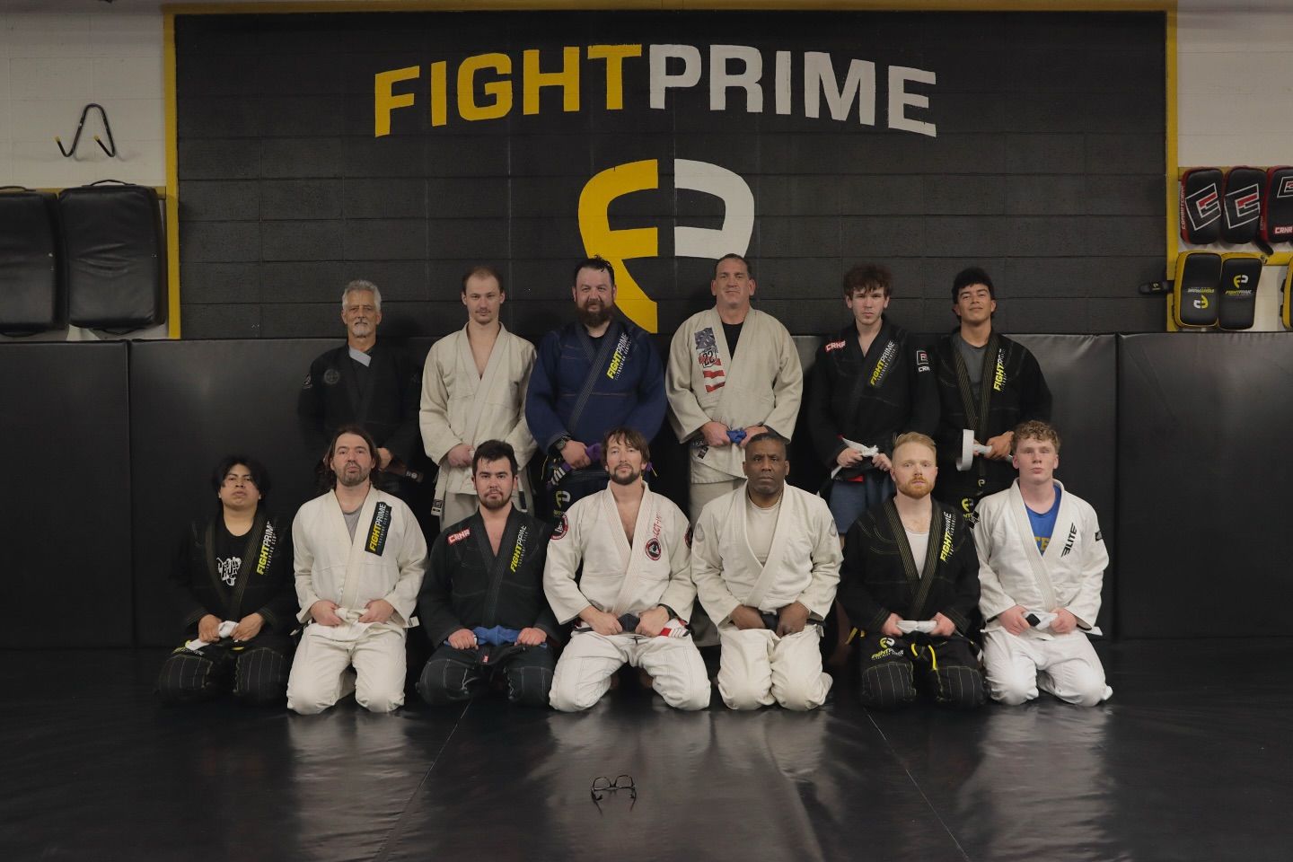 A group of people are posing for a picture in front of a sign that says fight prime