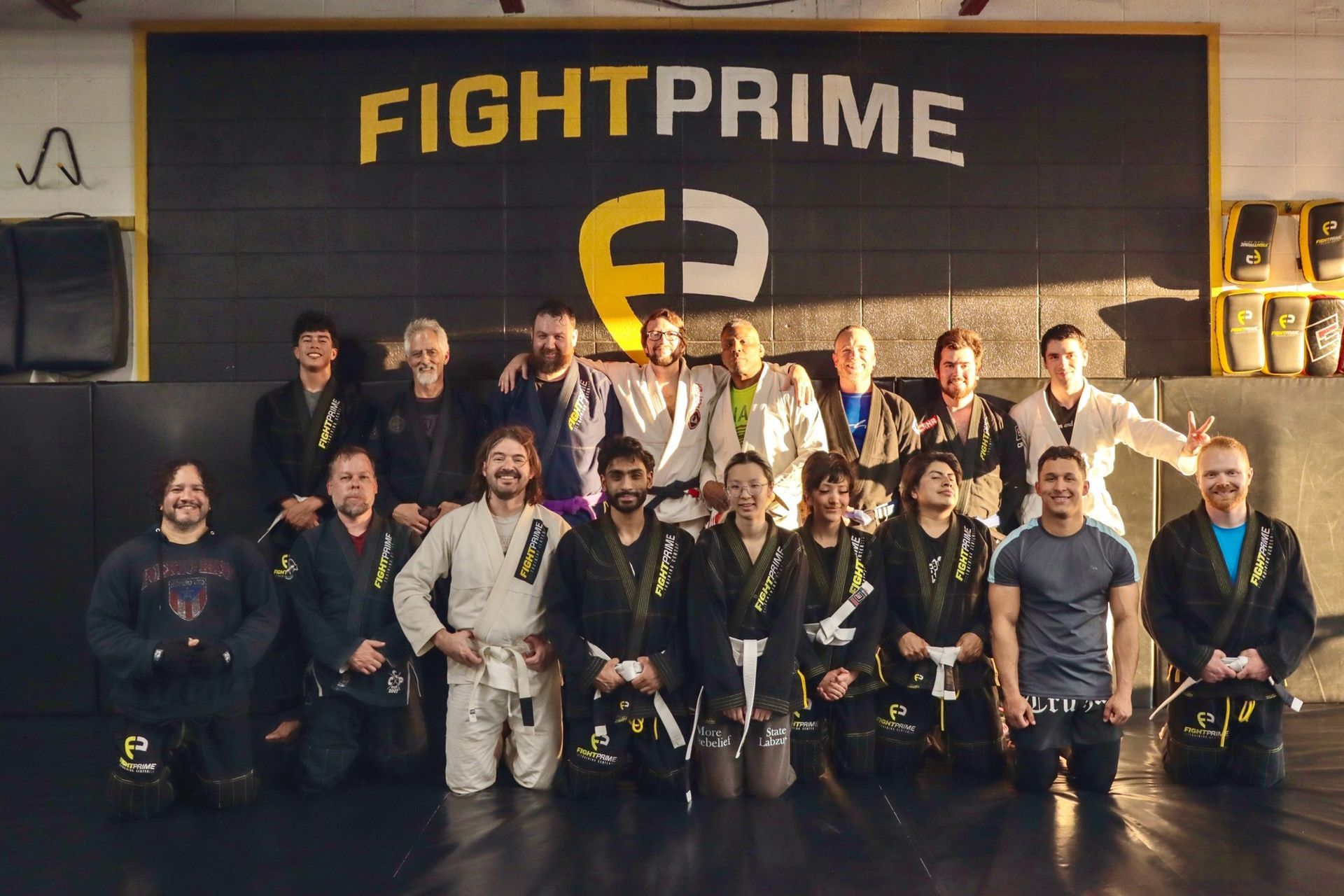 A group of men are posing for a picture in front of a fight prime sign.
