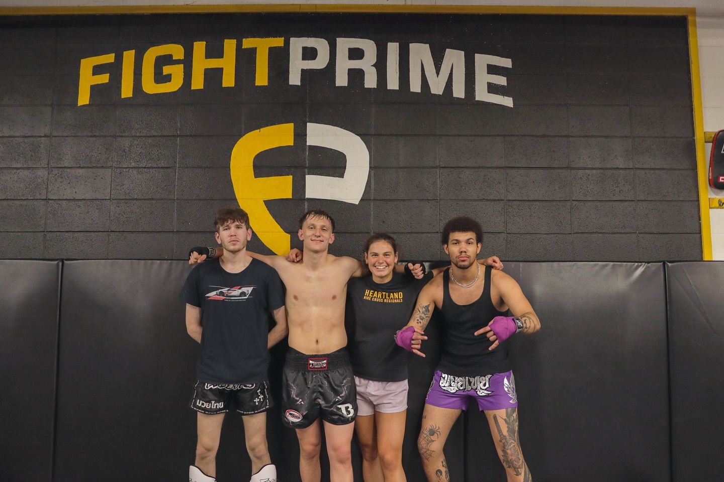A group of people are posing for a picture in front of a sign that says fight prime.