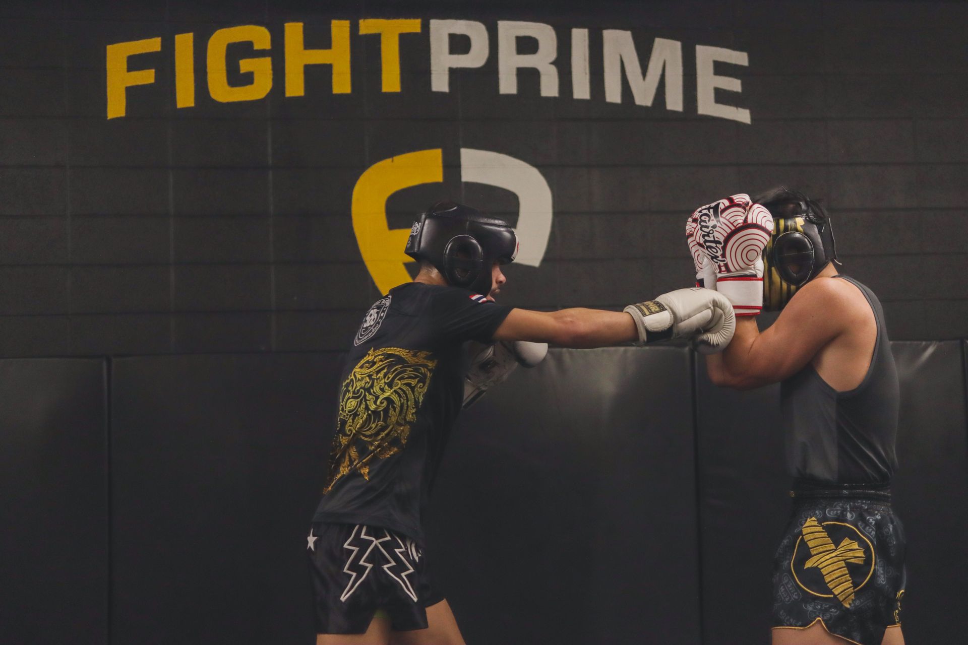 Two men are boxing in front of a sign that says fight prime