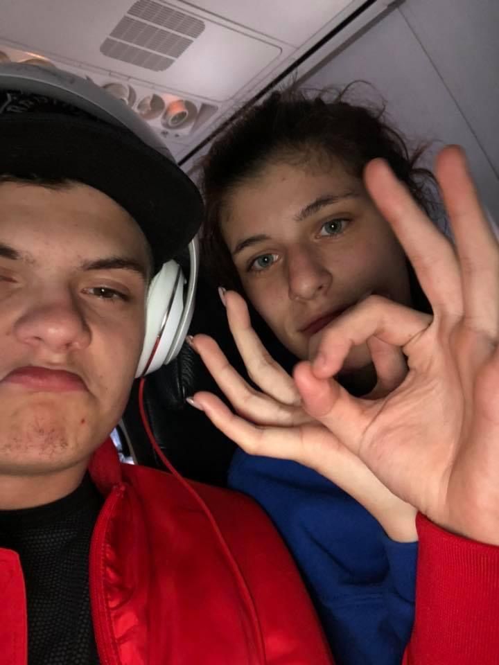 A man and a woman are posing for a picture on an airplane