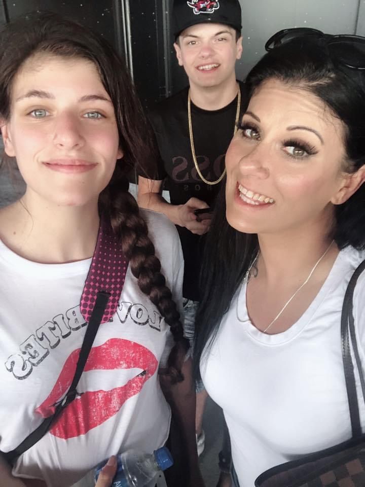 A woman wearing a t-shirt that says i love you is posing for a picture with two other people