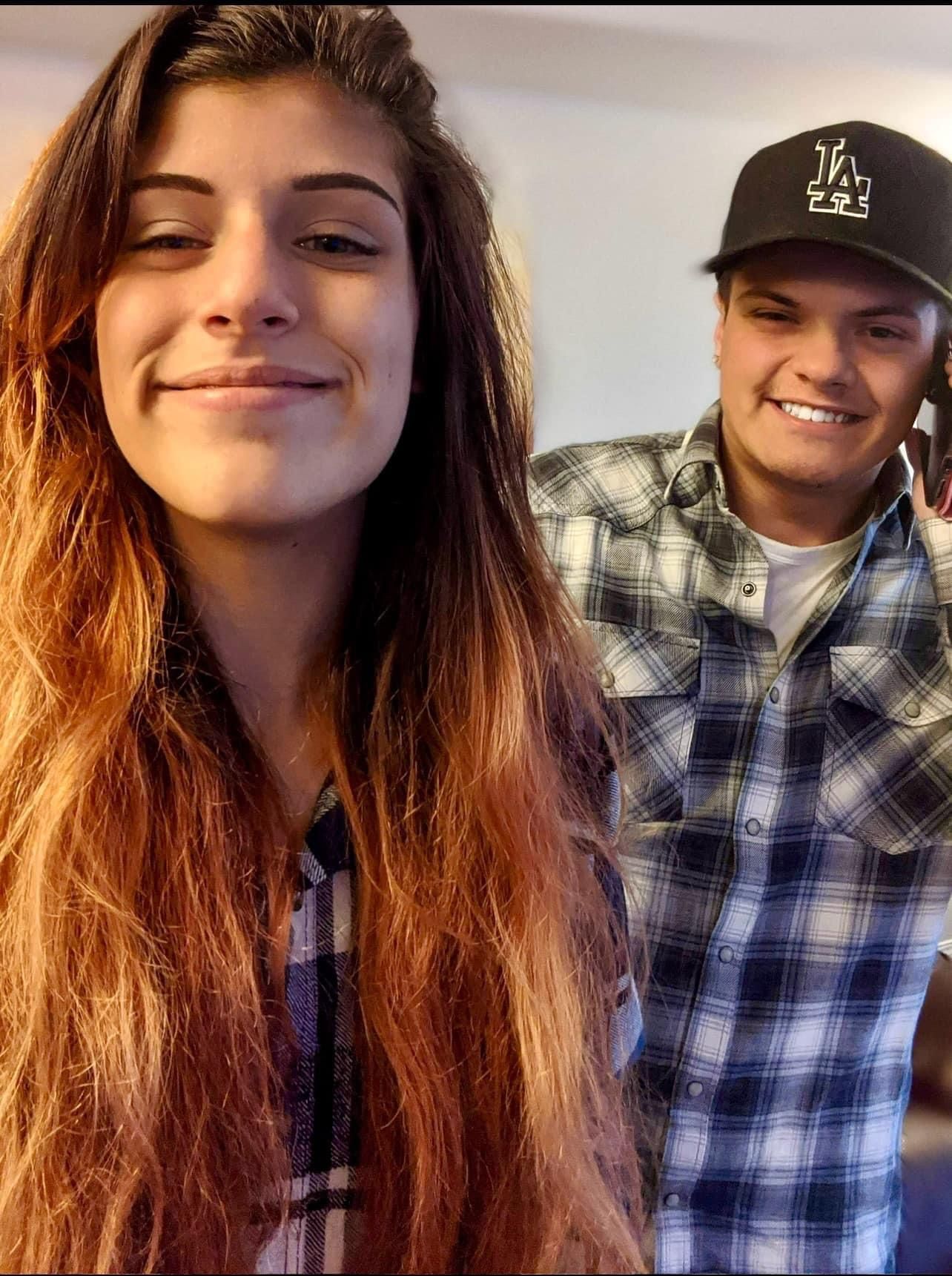 A man wearing a la hat is standing next to a woman