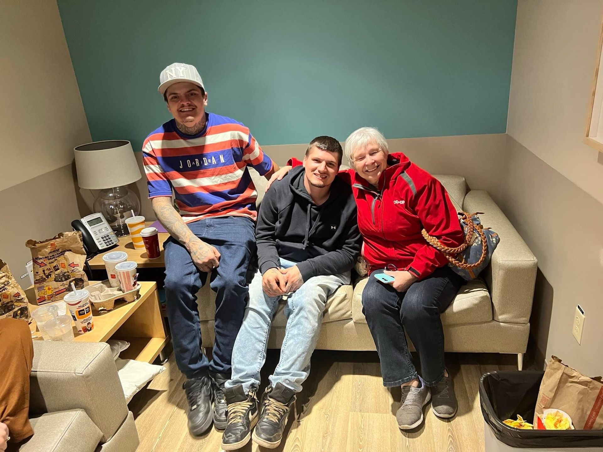 A group of people are sitting on a couch in a living room.