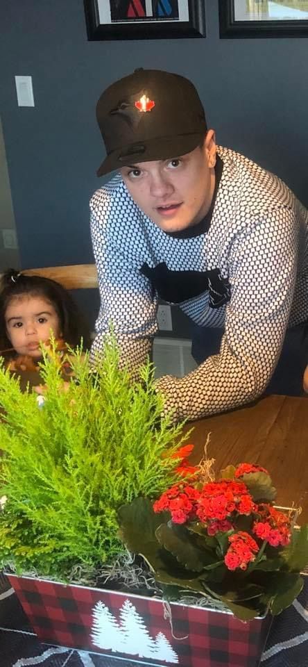 A man and a little girl are sitting at a table with a potted plant.