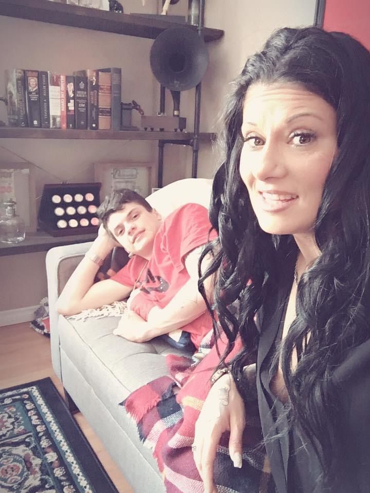 A woman sitting next to a boy on a couch