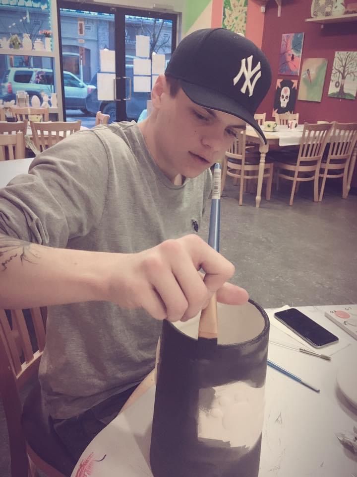 A man wearing a ny hat is sitting at a table