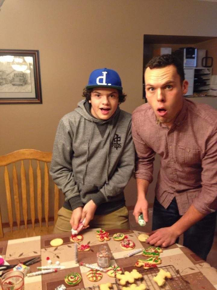 A boy wearing a blue hat with the letter d on it