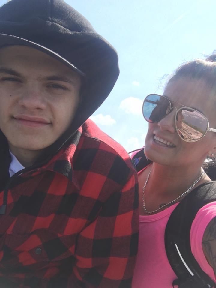 A man and a woman are posing for a picture and the woman is wearing sunglasses.