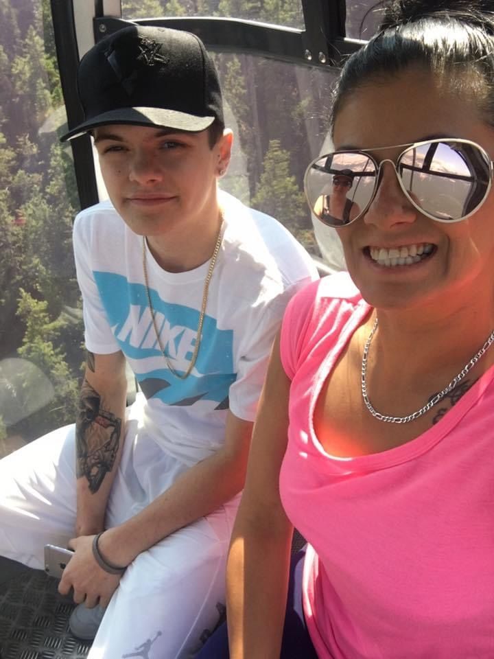 A man wearing a nike shirt sits next to a woman wearing sunglasses