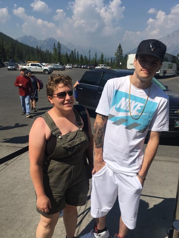 A man wearing a nike shirt stands next to a woman