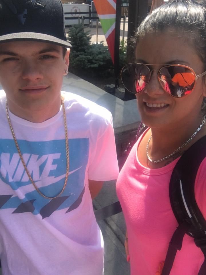 A boy wearing a nike shirt is standing next to a girl wearing sunglasses