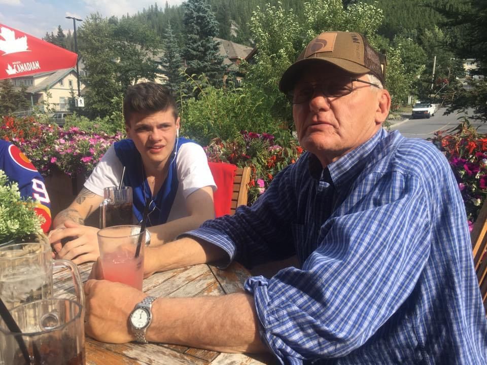 A man and a boy are sitting at a table with drinks.