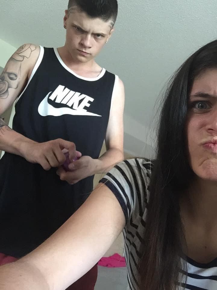 A man wearing a nike tank top stands next to a woman