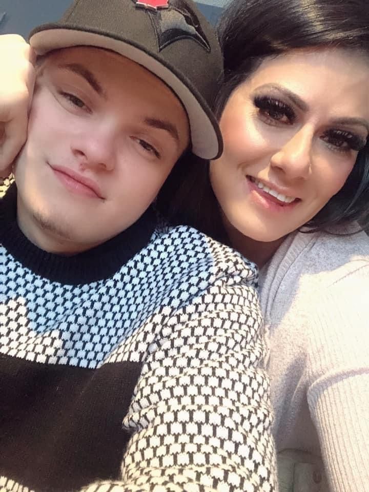 A woman and a boy are posing for a picture