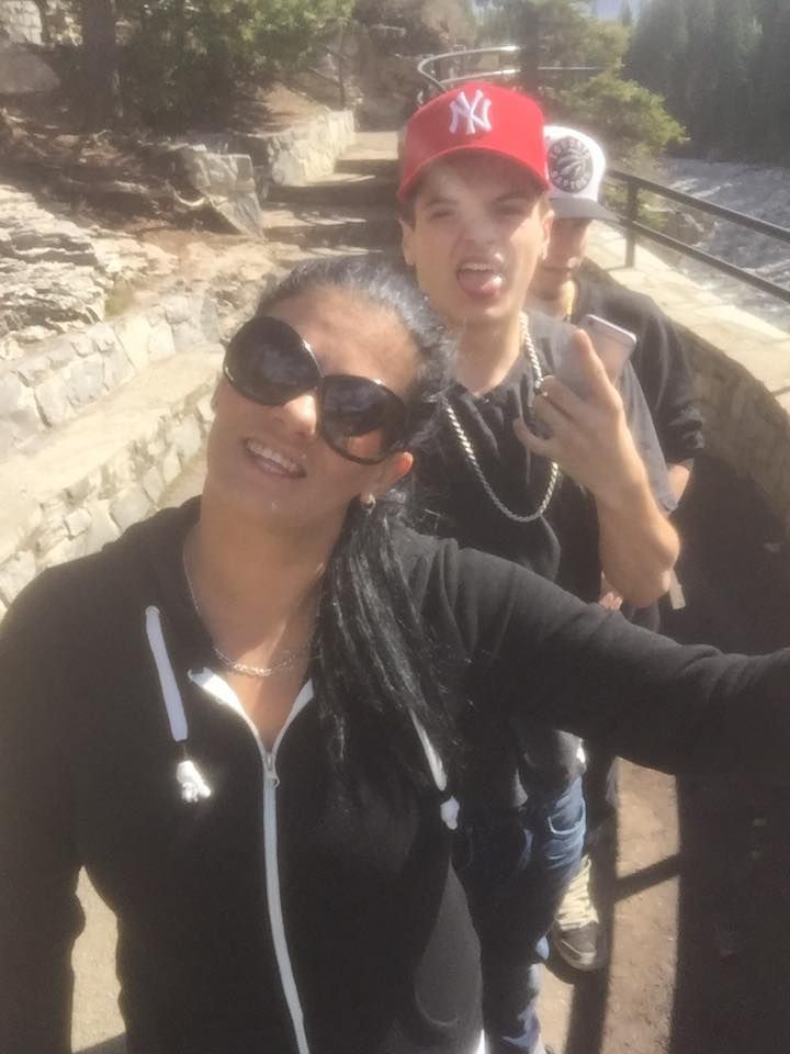 A man wearing a ny hat stands next to a woman wearing sunglasses