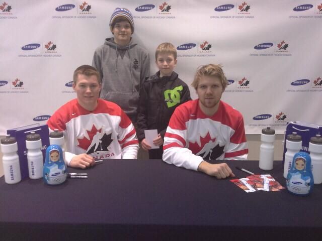 A man in a dc shirt sits at a table with two other men