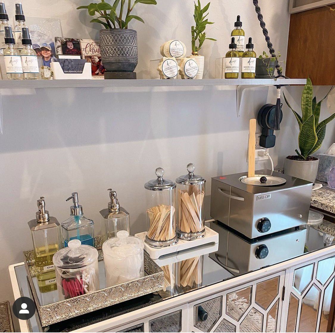 A shelf with bottles of perfume and candles on it