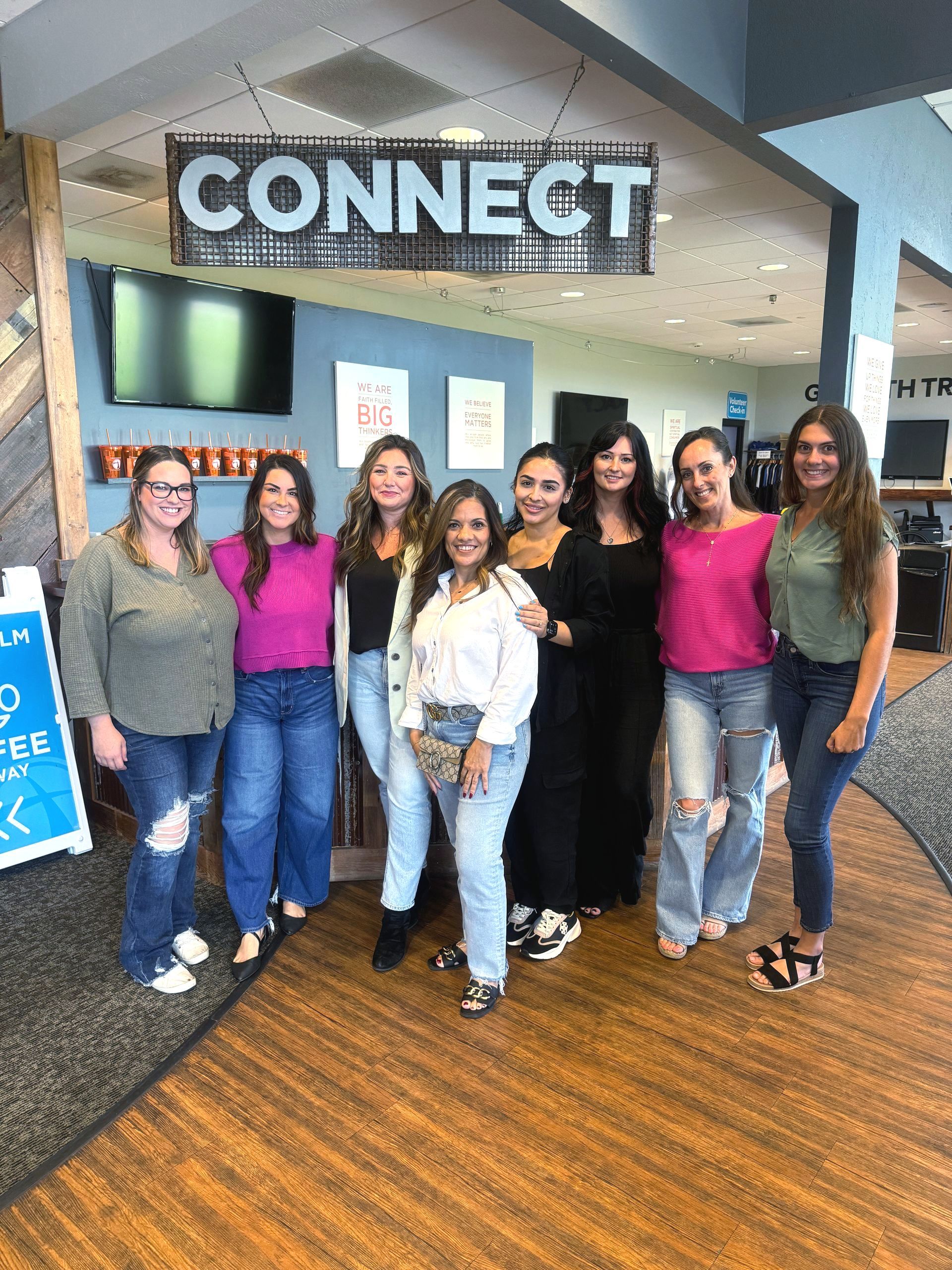 Group of people in front of a sign.