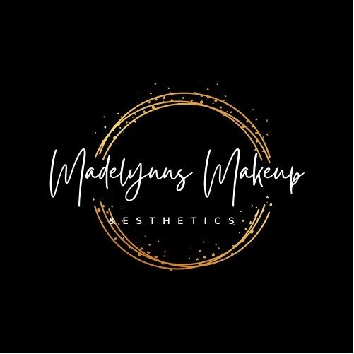 A logo for a makeup artist with a gold circle in the middle on a black background.