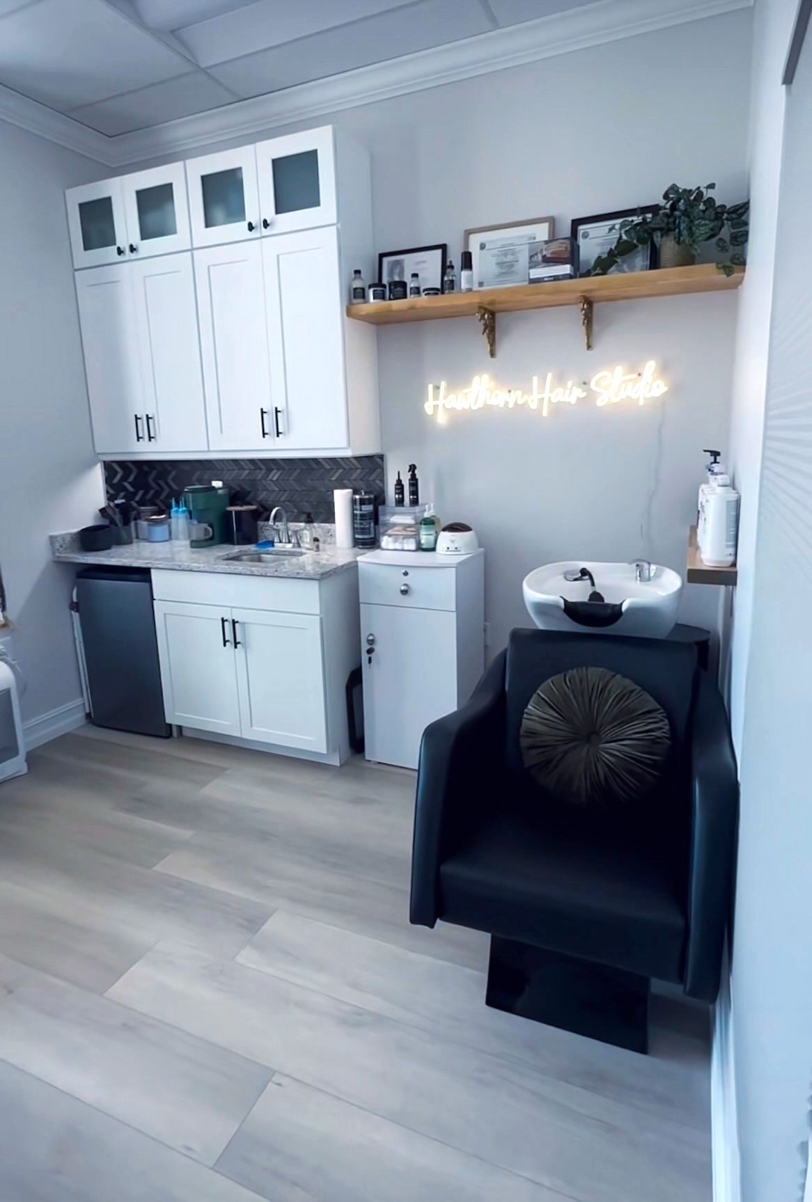 A hair salon with a chair and a sink.