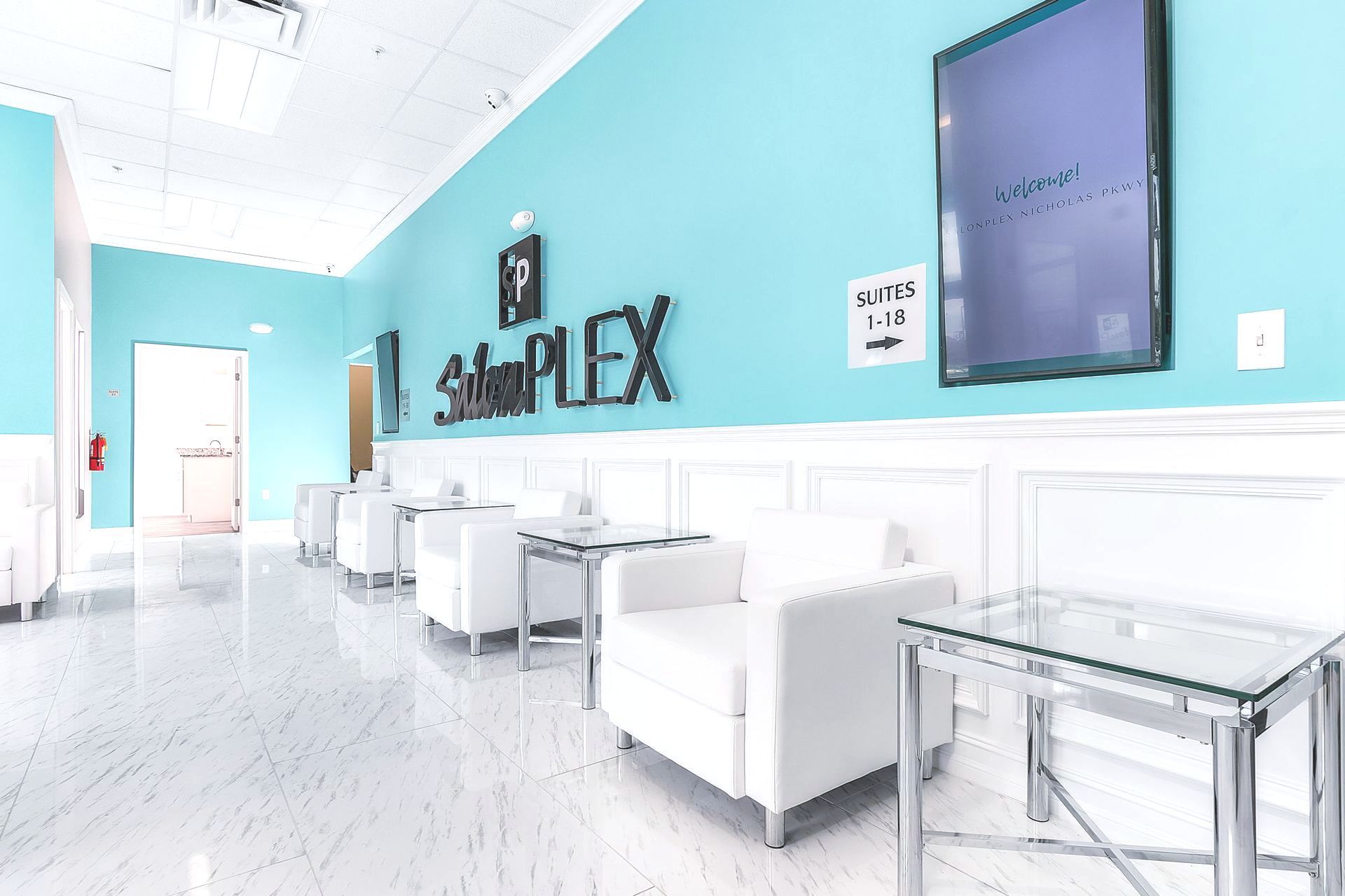 The interior of a salon plex with blue walls and white furniture