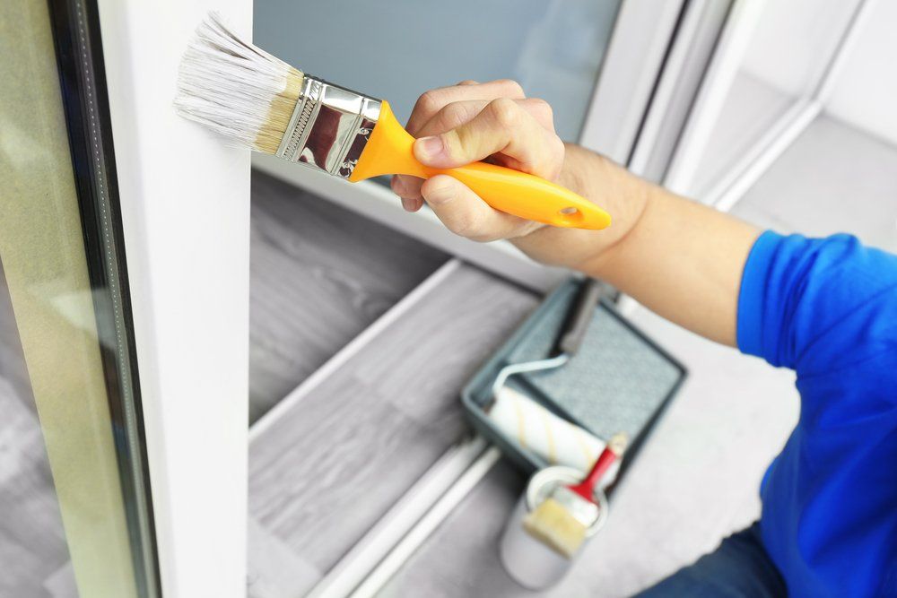 Young Man Painting Window At Home — Vandaline Painting Contractors in Forster, NSW