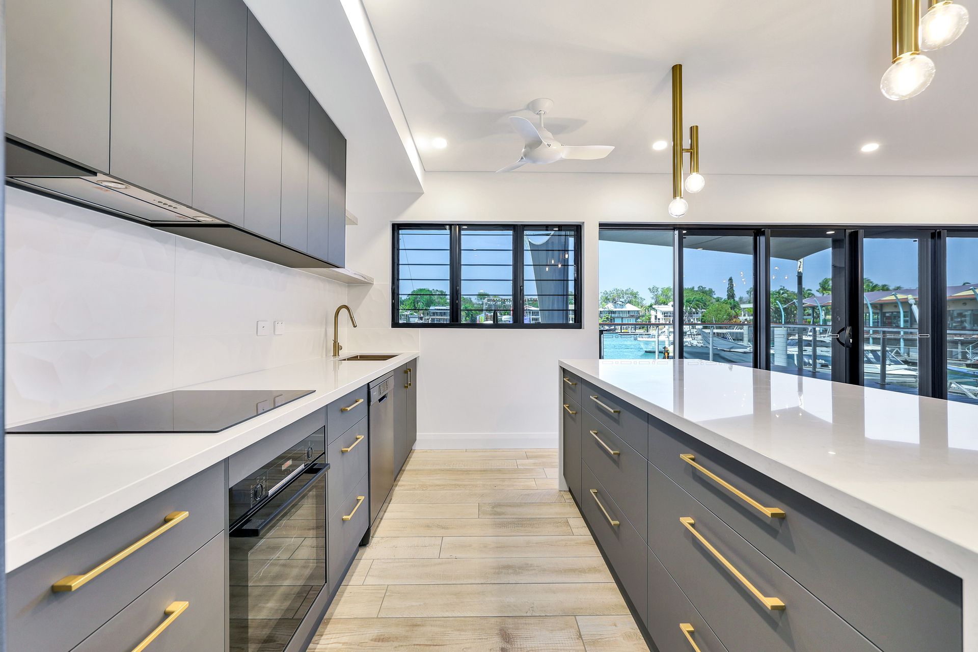 Modern kitchen with gray cabinets, white countertops, and a large island.