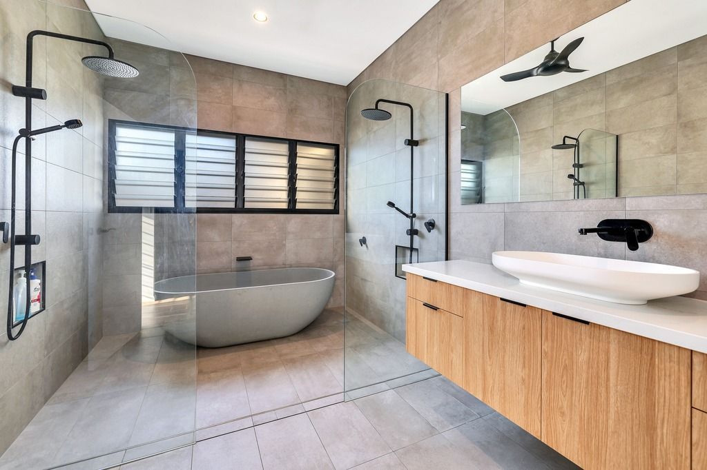 Modern bathroom with a freestanding tub, glass shower, and wooden vanity.