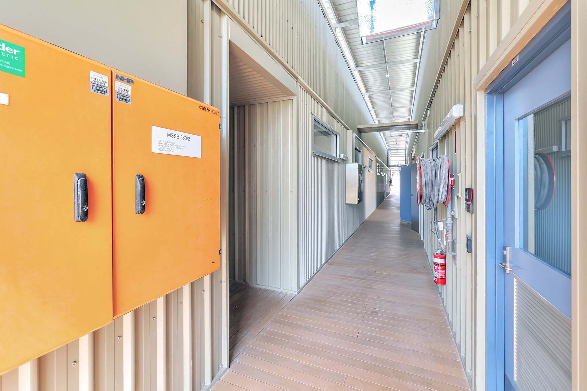 Long hallway with utility cupboards, fire house and extinguisher