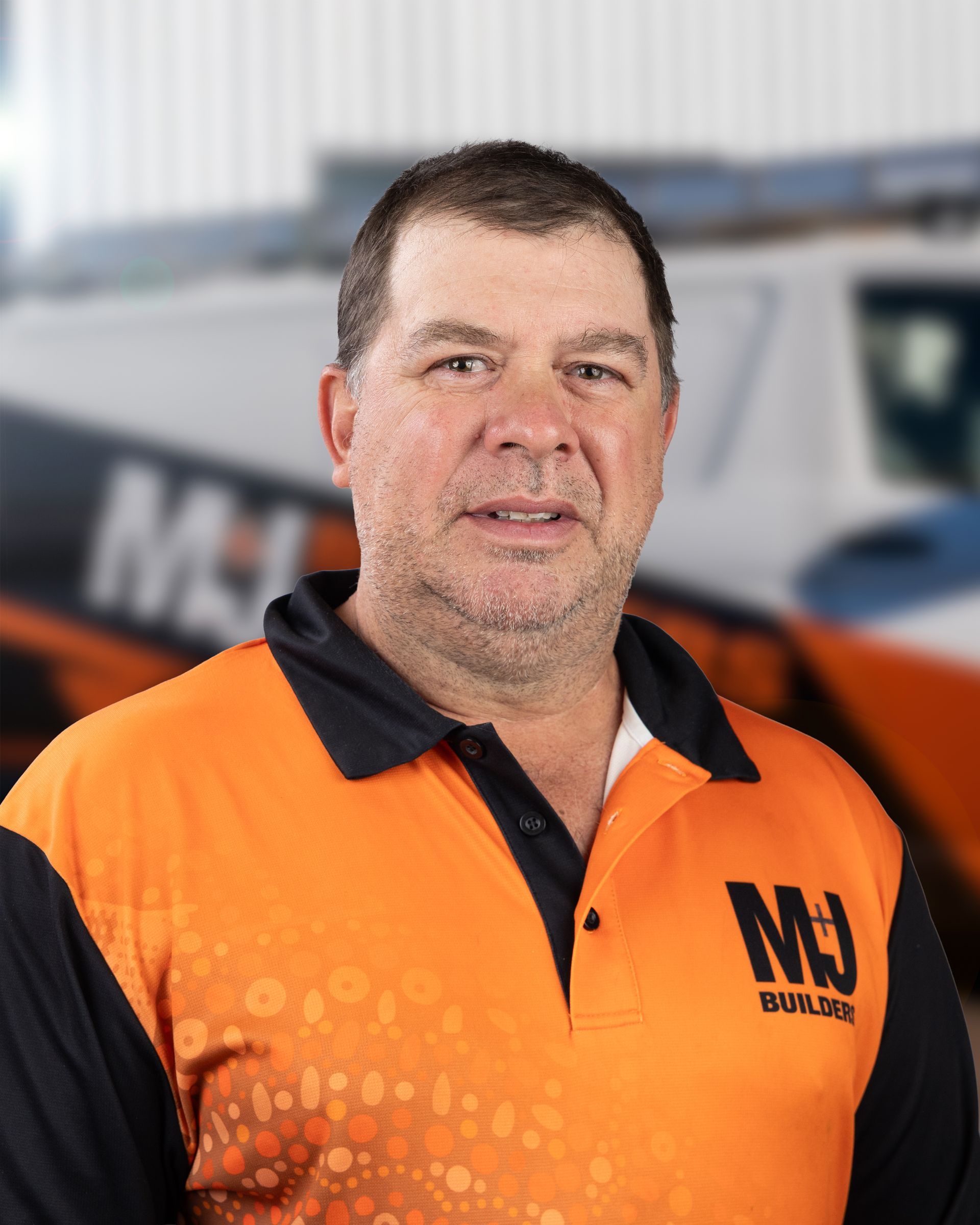 Man wearing orange and black polo shirt with