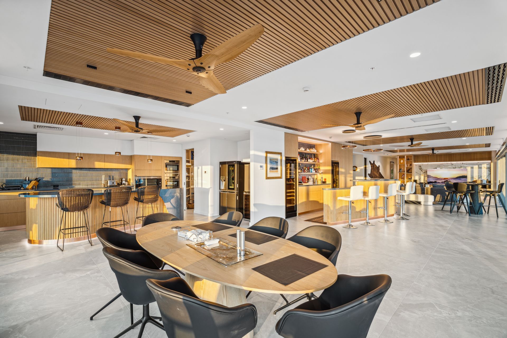 Upscale open dining area with a large oval table, chairs, and bar area.